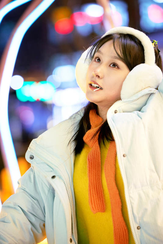 冬季夜晚在都市街头拍照的东方美女