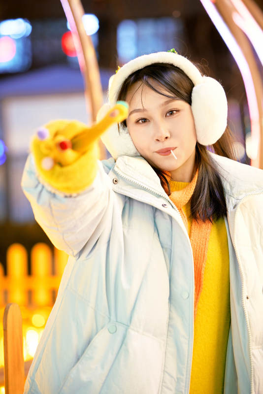 冬季夜晚在都市街头拍照的东方美女