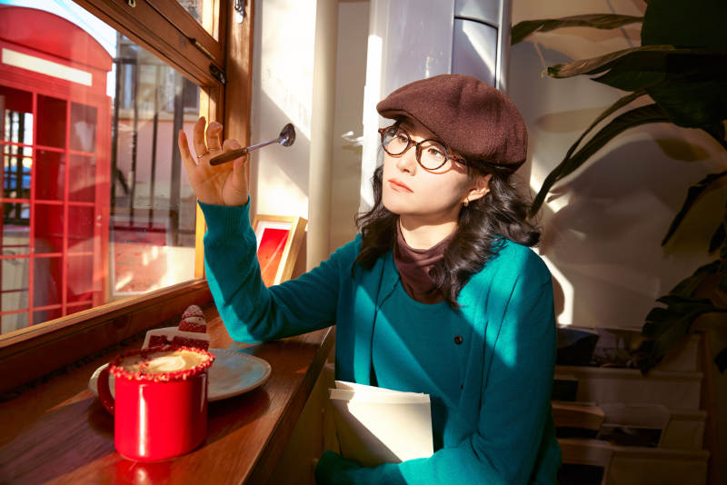 冬日午后坐在咖啡店吃蛋糕喝咖啡的亚洲美女