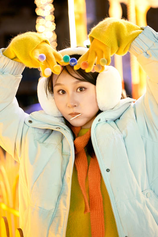 冬季夜晚在都市街头拍照的东方美女