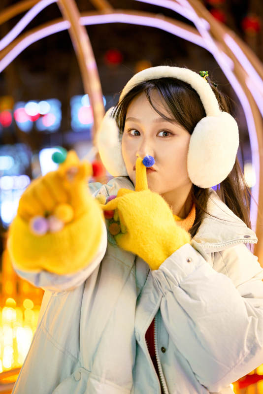 冬季夜晚在都市街头拍照的东方美女