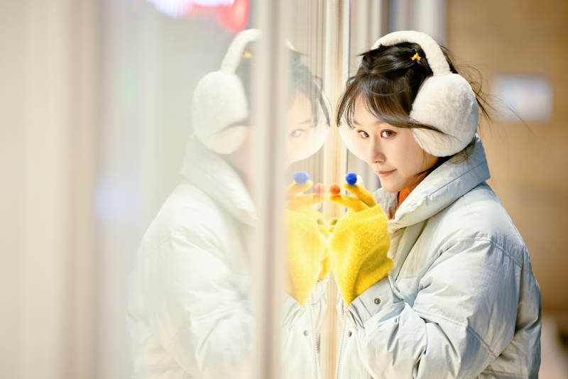 冬季夜晚在都市街头拍照的东方美女