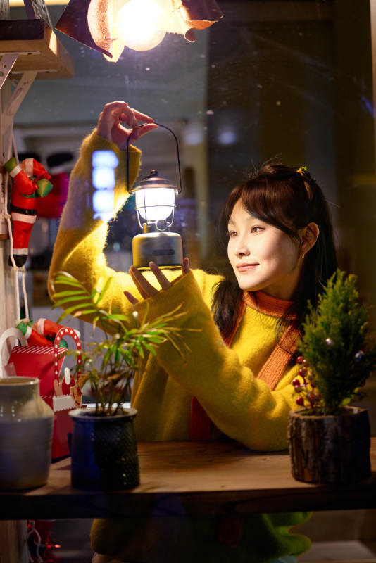 冬季夜晚在咖啡店品尝咖啡的东方美女