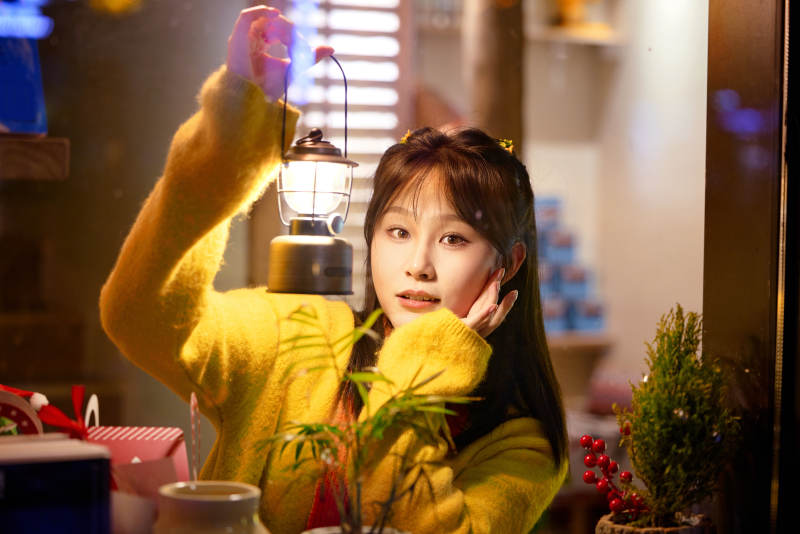 冬季夜晚在咖啡店品尝咖啡的东方美女