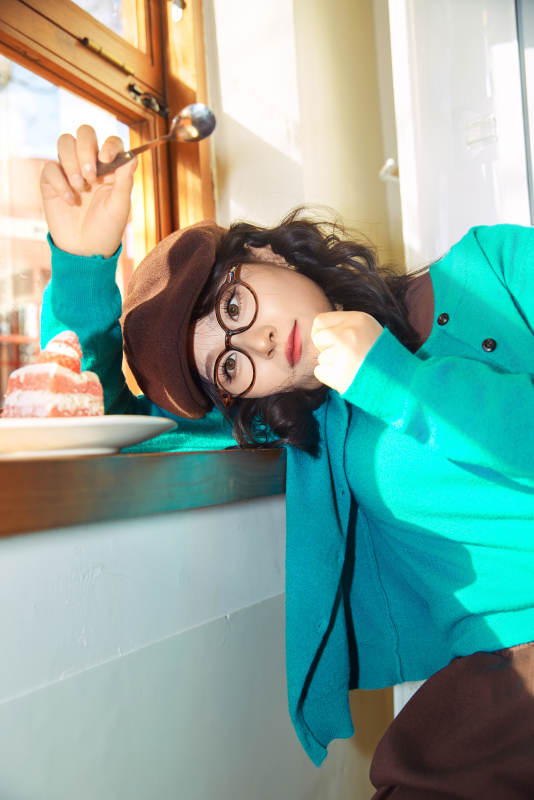 冬日午后坐在咖啡店吃蛋糕喝咖啡的亚洲美女