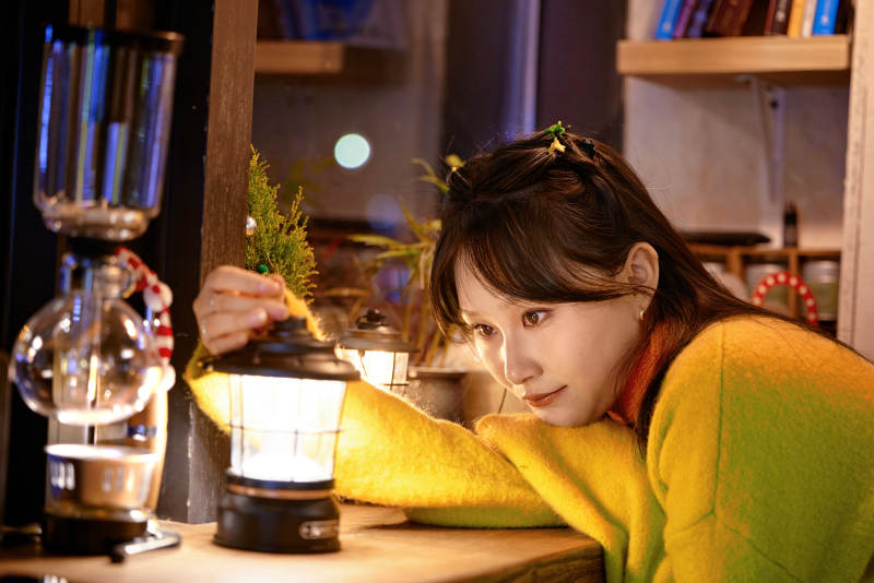 冬季夜晚在咖啡店品尝咖啡的东方美女