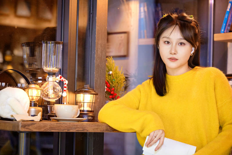 冬季夜晚在咖啡店品尝咖啡的东方美女