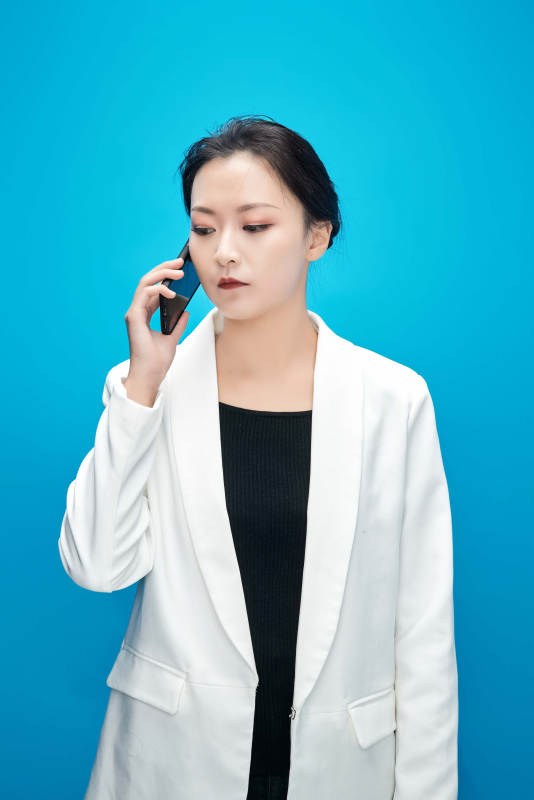 身穿西服拿着手机与文件夹的亚洲商务女士