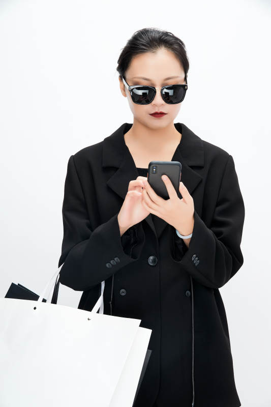 白色背景下手提购物袋时尚美丽的亚洲少女