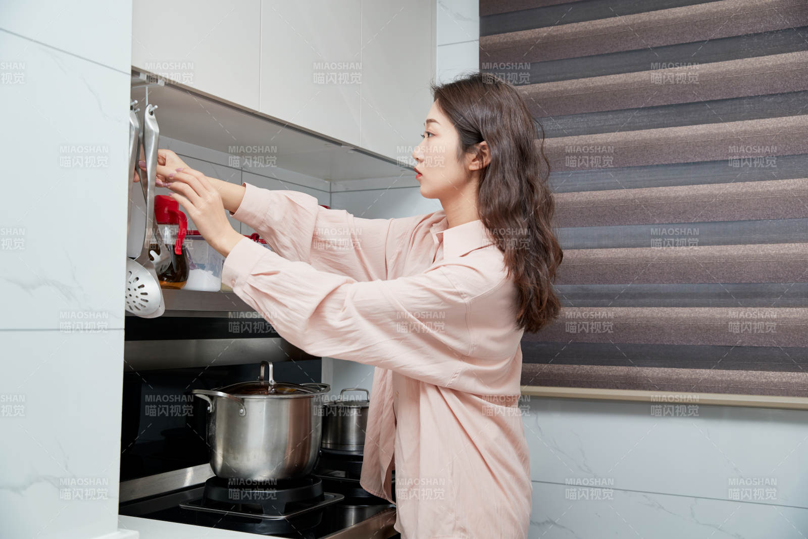 在廚房下廚的年輕亞洲女性