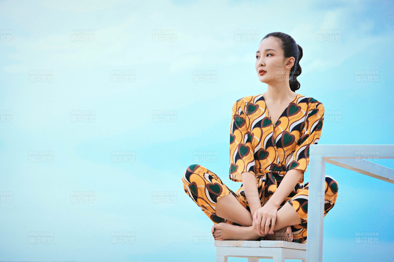 悠闲的坐在美丽湖岸码头的亚洲年轻女性人像