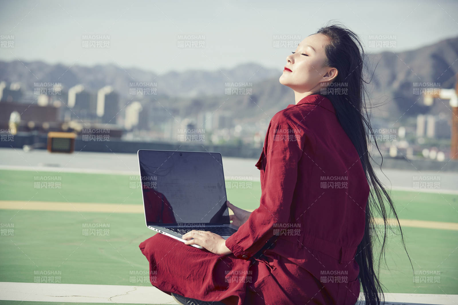 亚洲商务年轻女性在楼顶停机坪使用电脑办公图片