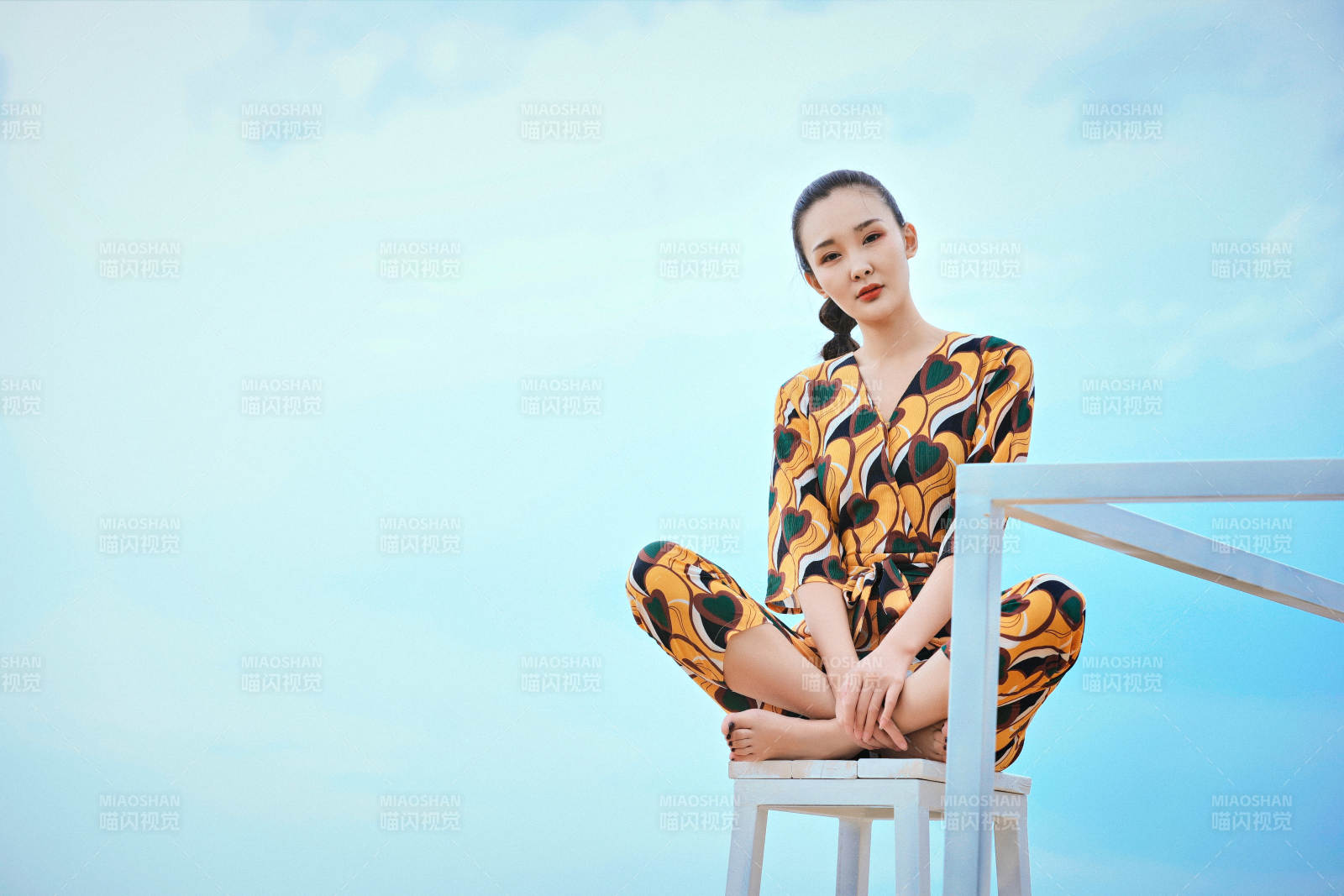 悠闲的坐在美丽湖岸码头的亚洲年轻女性人像