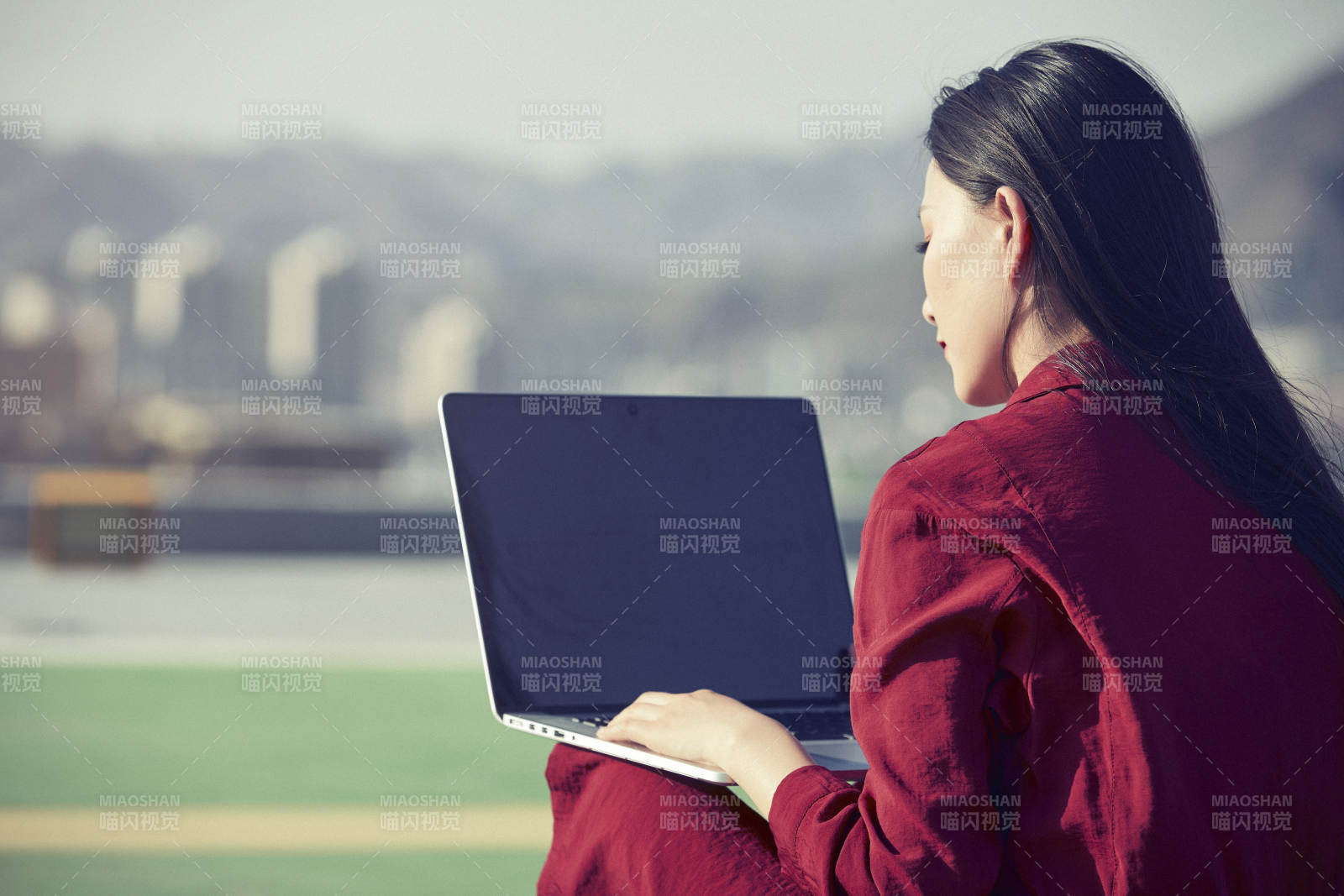 亚洲商务年轻女性在楼顶停机坪使用电脑办公