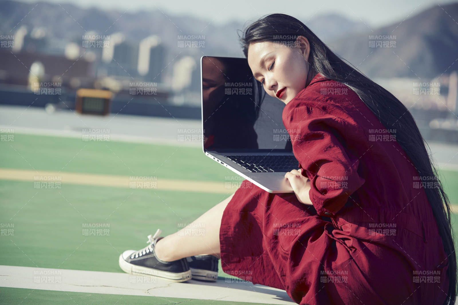 亚洲商务年轻女性在楼顶停机坪使用电脑办公