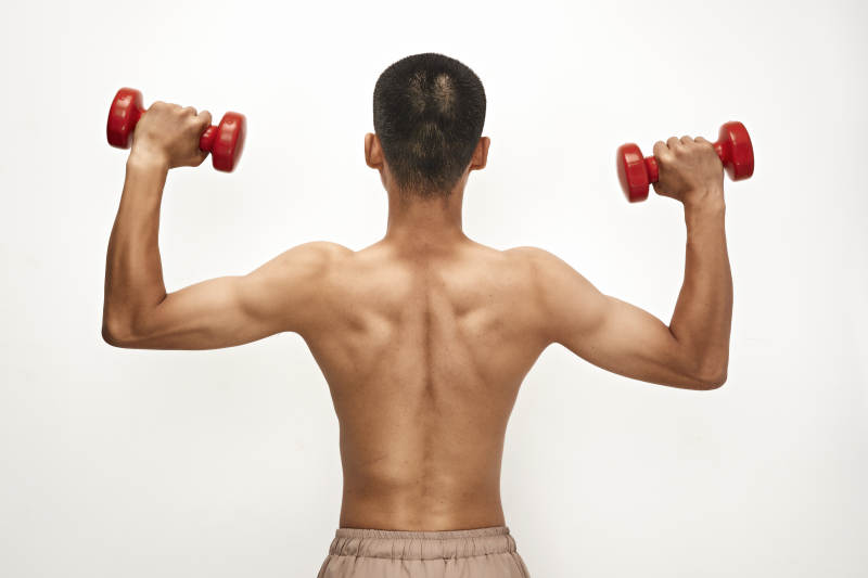 使用哑铃进行健身锻炼的亚洲男性