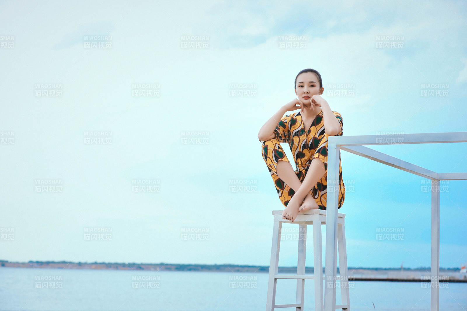 悠闲的坐在美丽湖岸码头的亚洲年轻女性人像