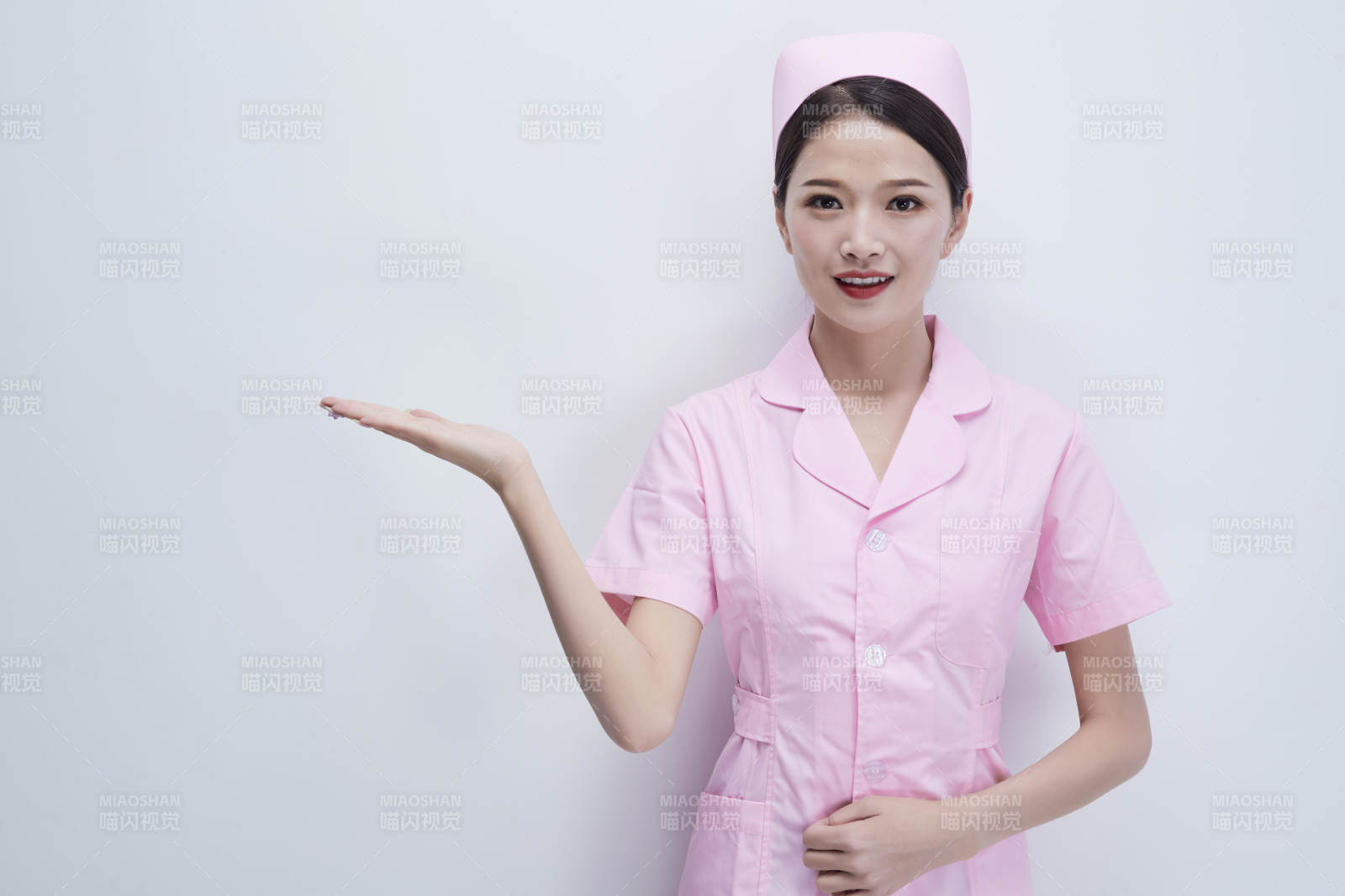 身穿粉色护士服佩戴听诊器的女性医护人员图片