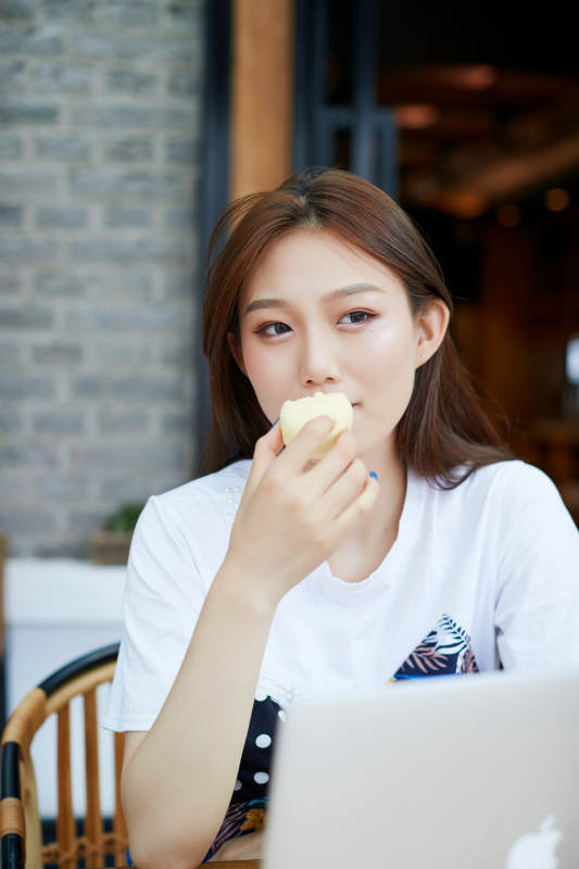 坐在咖啡图书馆吃东西的可爱少女