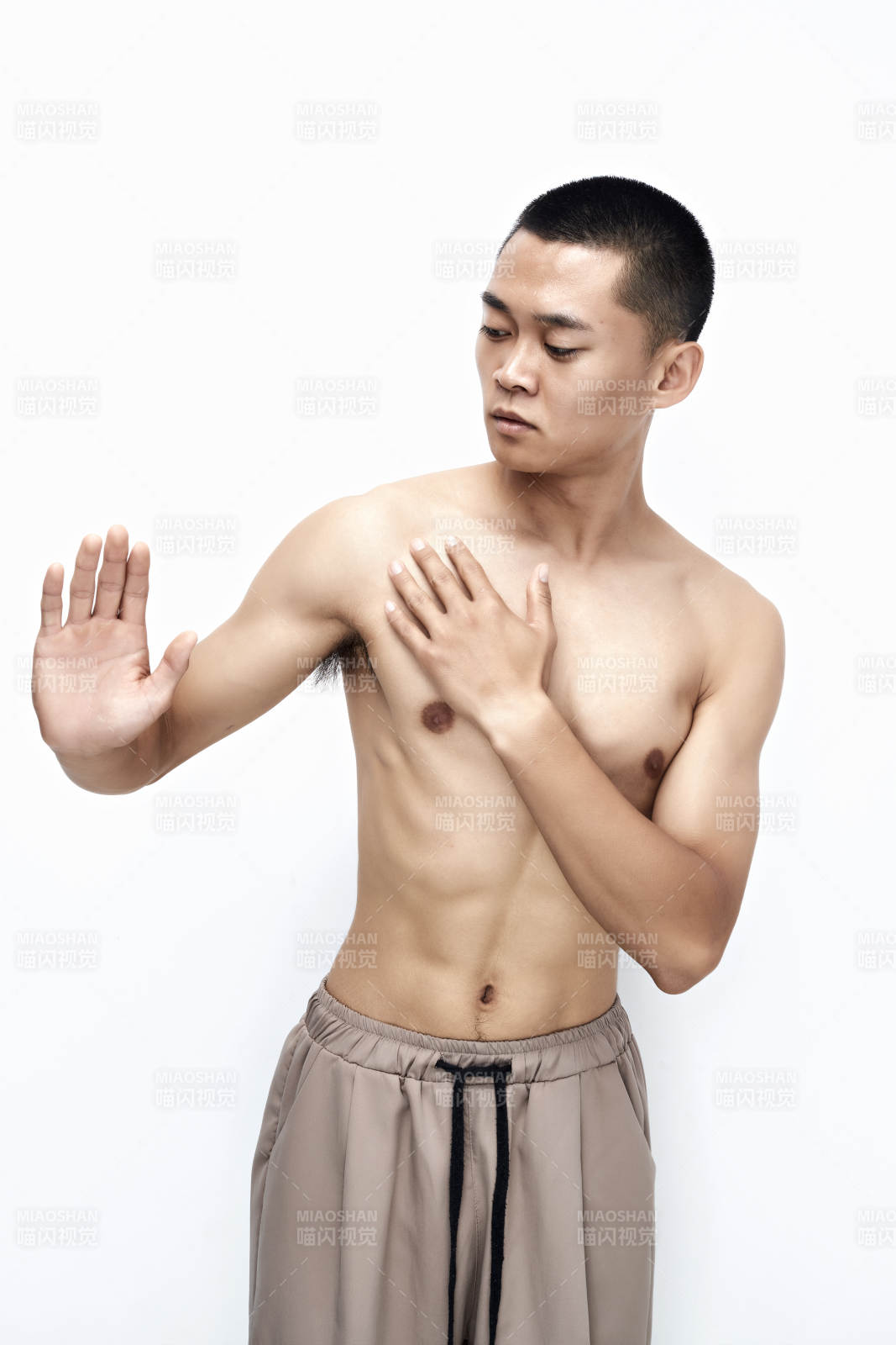 白色背景下展示健身预备拉伸动作的亚洲男性