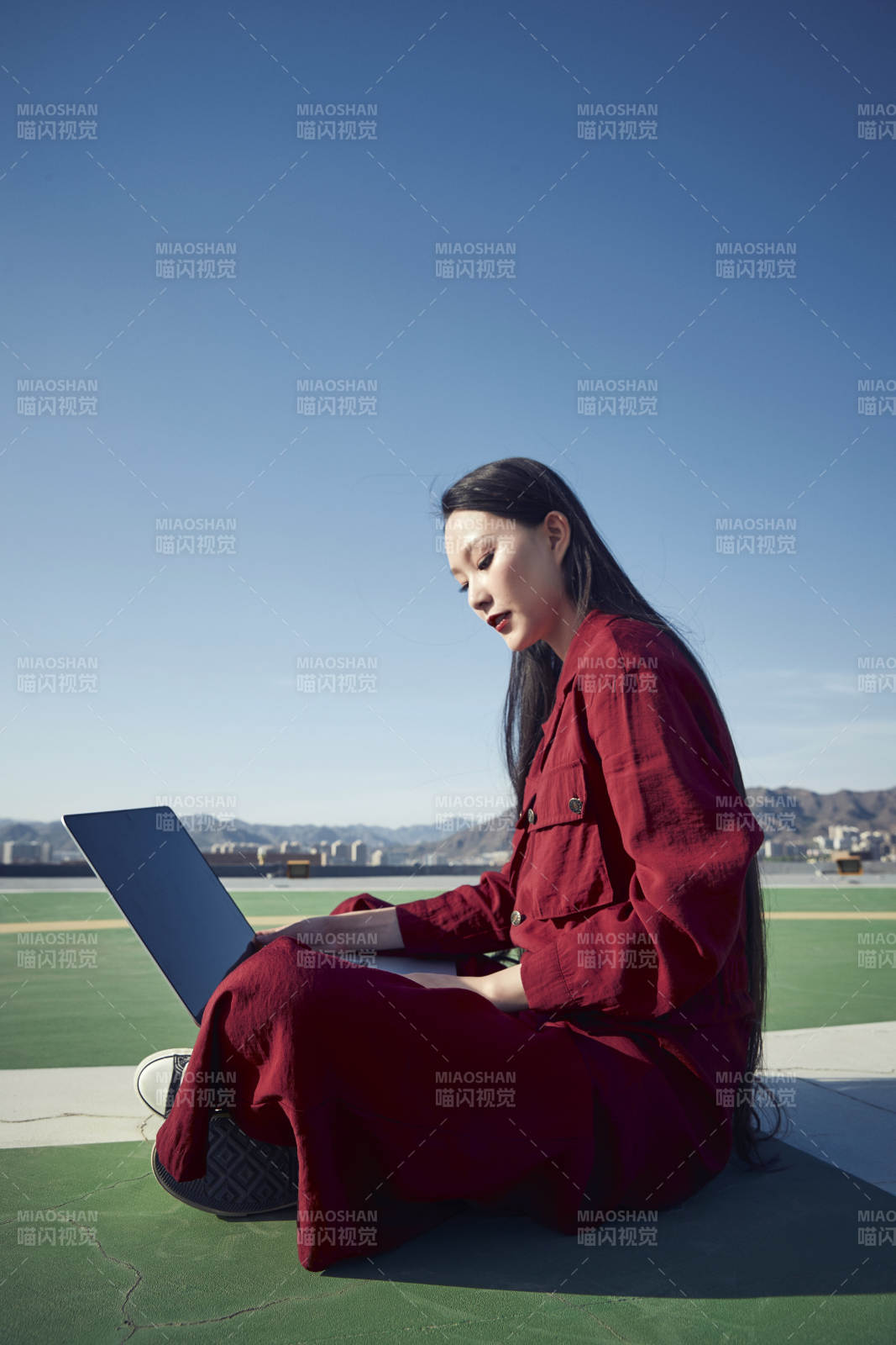 亚洲商务年轻女性在楼顶停机坪使用电脑办公