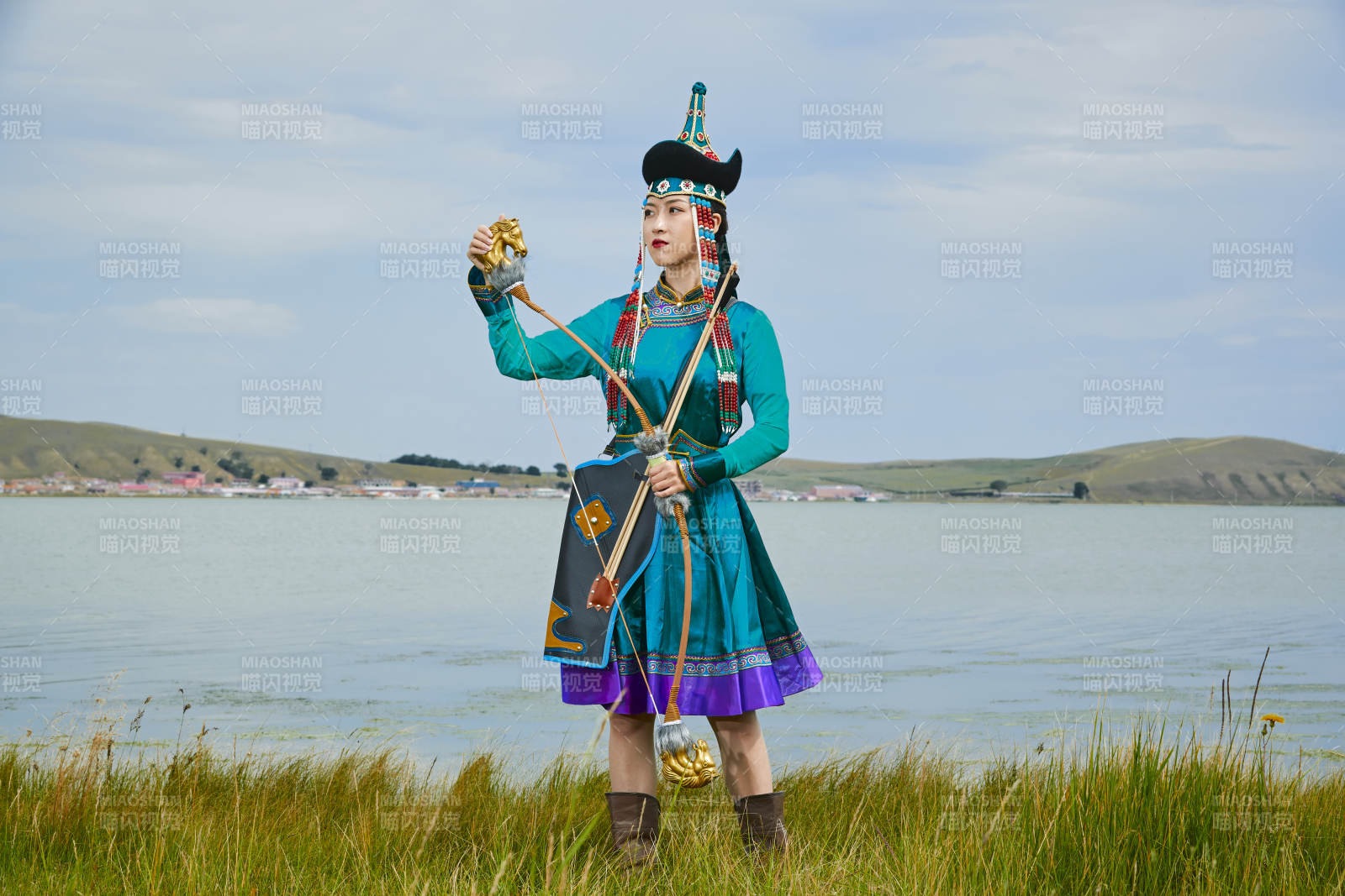 草原湖畔身穿蒙古族飾手持弓箭的蒙族少女