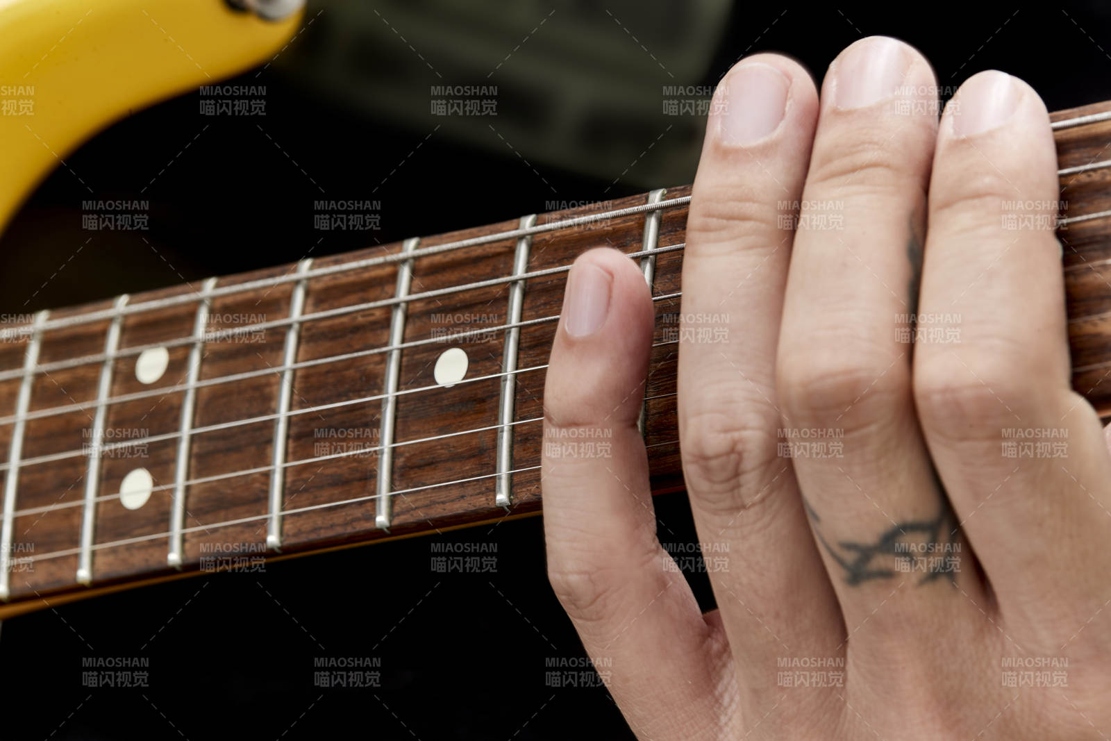 示范演奏搖滾電吉他的亞洲男性樂手人像局部特寫