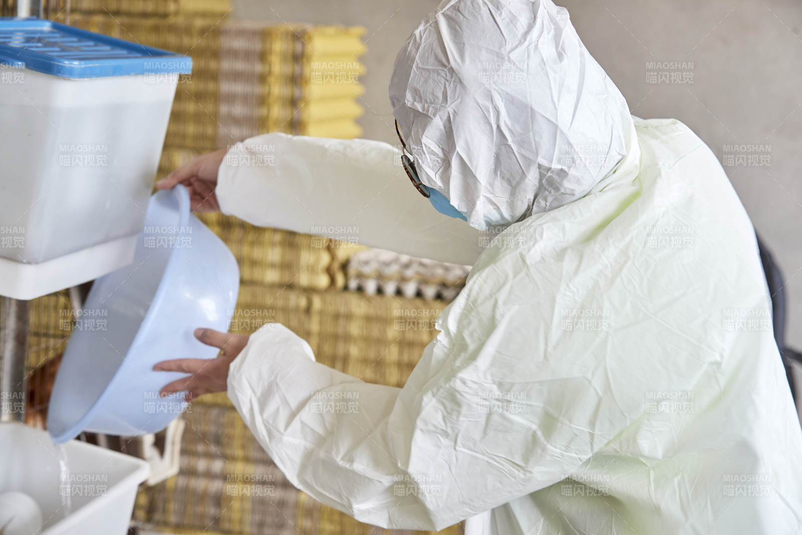 身穿防护服展示油鸡蛋的女性饲养员