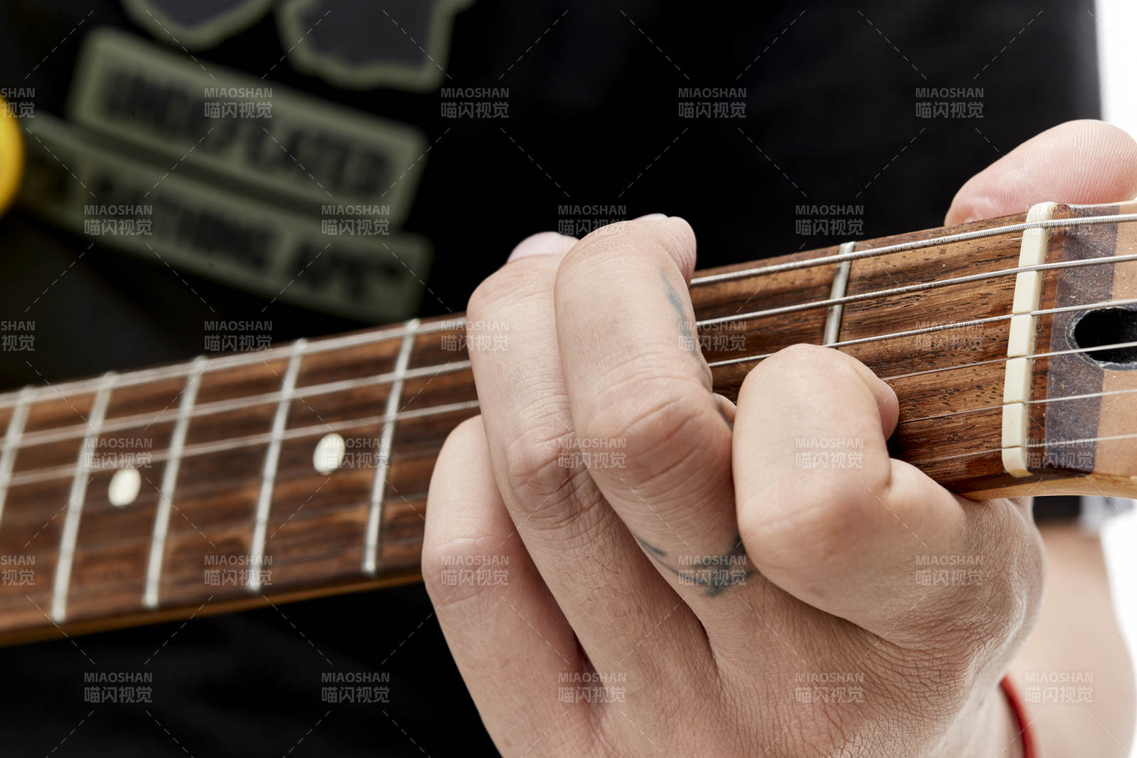 示范演奏搖滾電吉他的亞洲男性樂手人像局部特寫