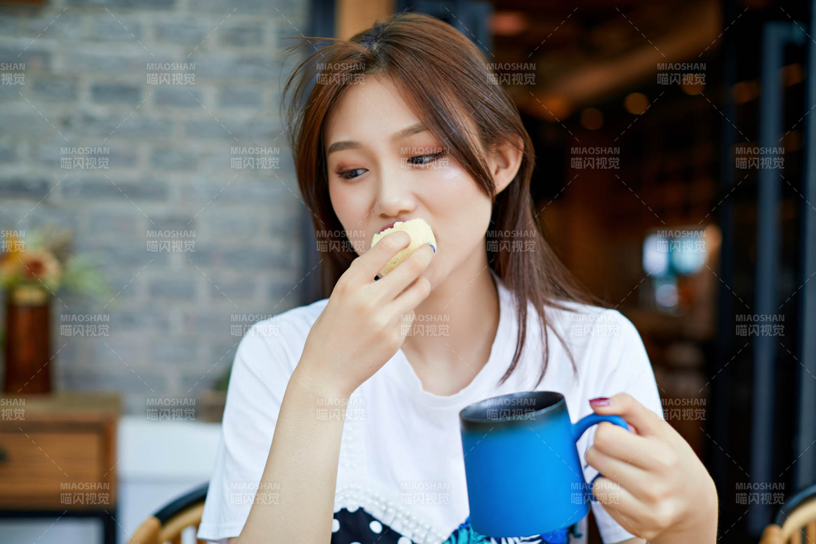 坐在咖啡圖書館吃東西的可愛少女