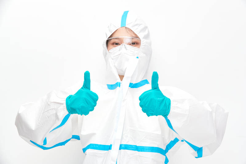 穿白色防护服佩戴护目镜口罩的女性医疗人员