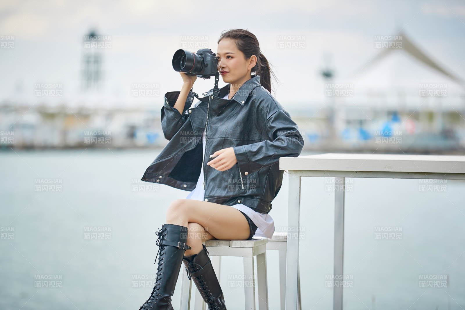 户外湖畔进行拍摄的亚洲青年女性摄影师