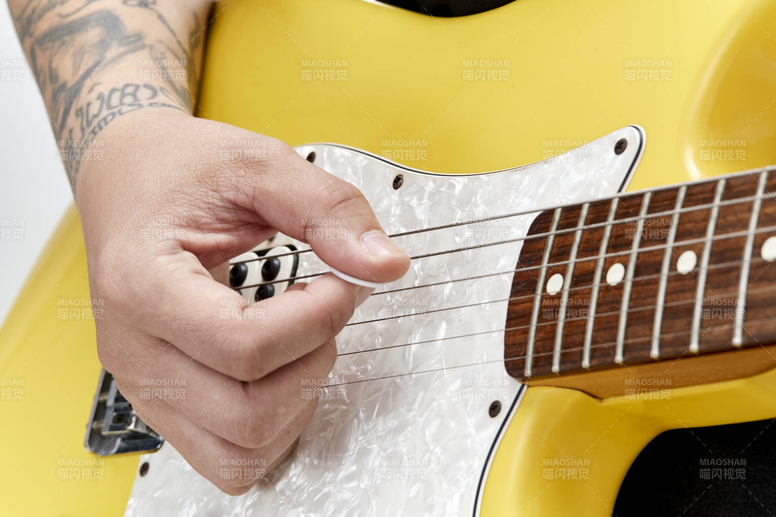 示范演奏搖滾電吉他的亞洲男性樂手人像局部特寫