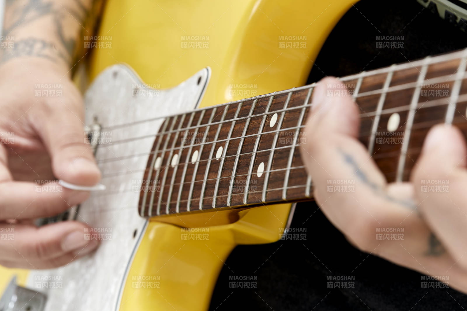 示范演奏摇滚电吉他的亚洲男性乐手人像局部特写