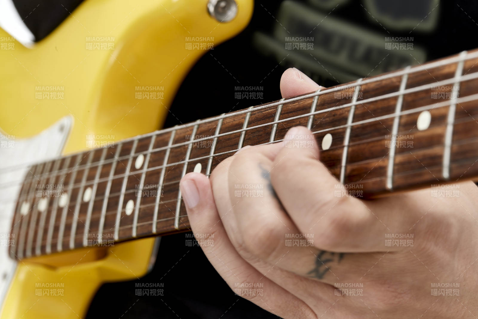 示范演奏搖滾電吉他的亞洲男性樂手人像局部特寫
