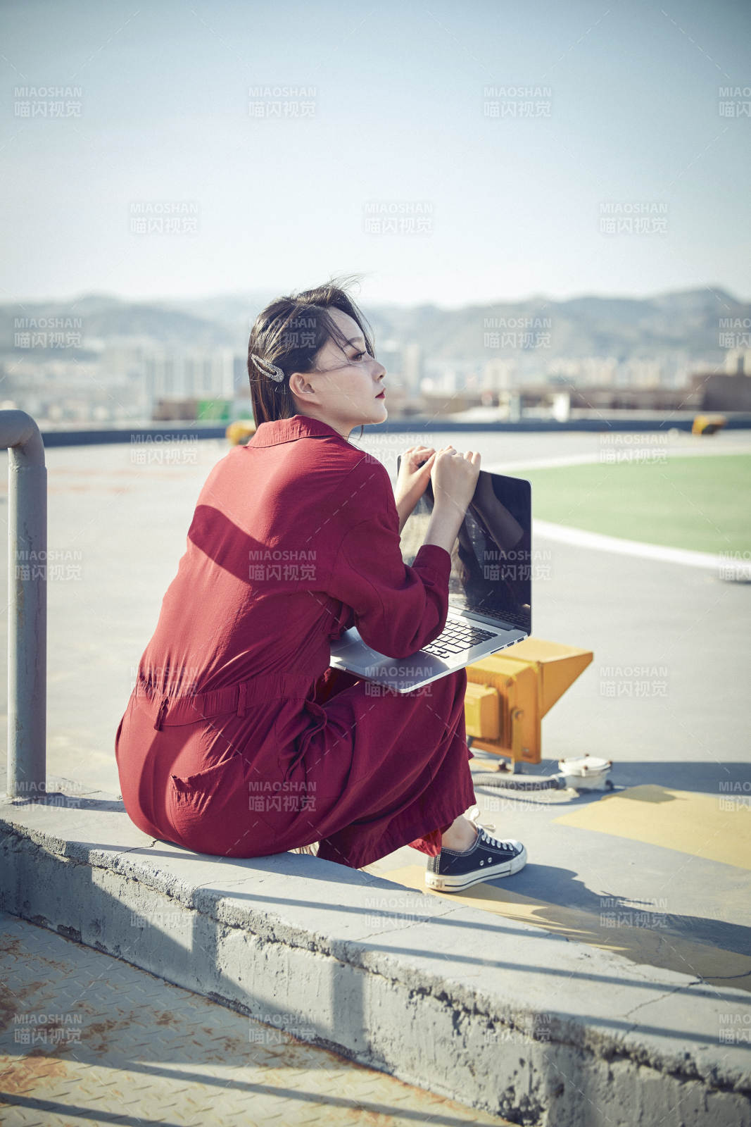亞洲商務(wù)年輕女性在樓頂停機(jī)坪使用電腦辦公