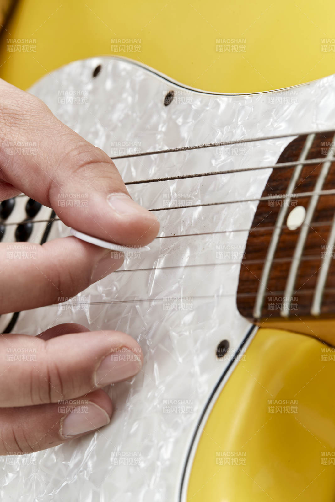 示范演奏搖滾電吉他的亞洲男性樂手人像局部特寫