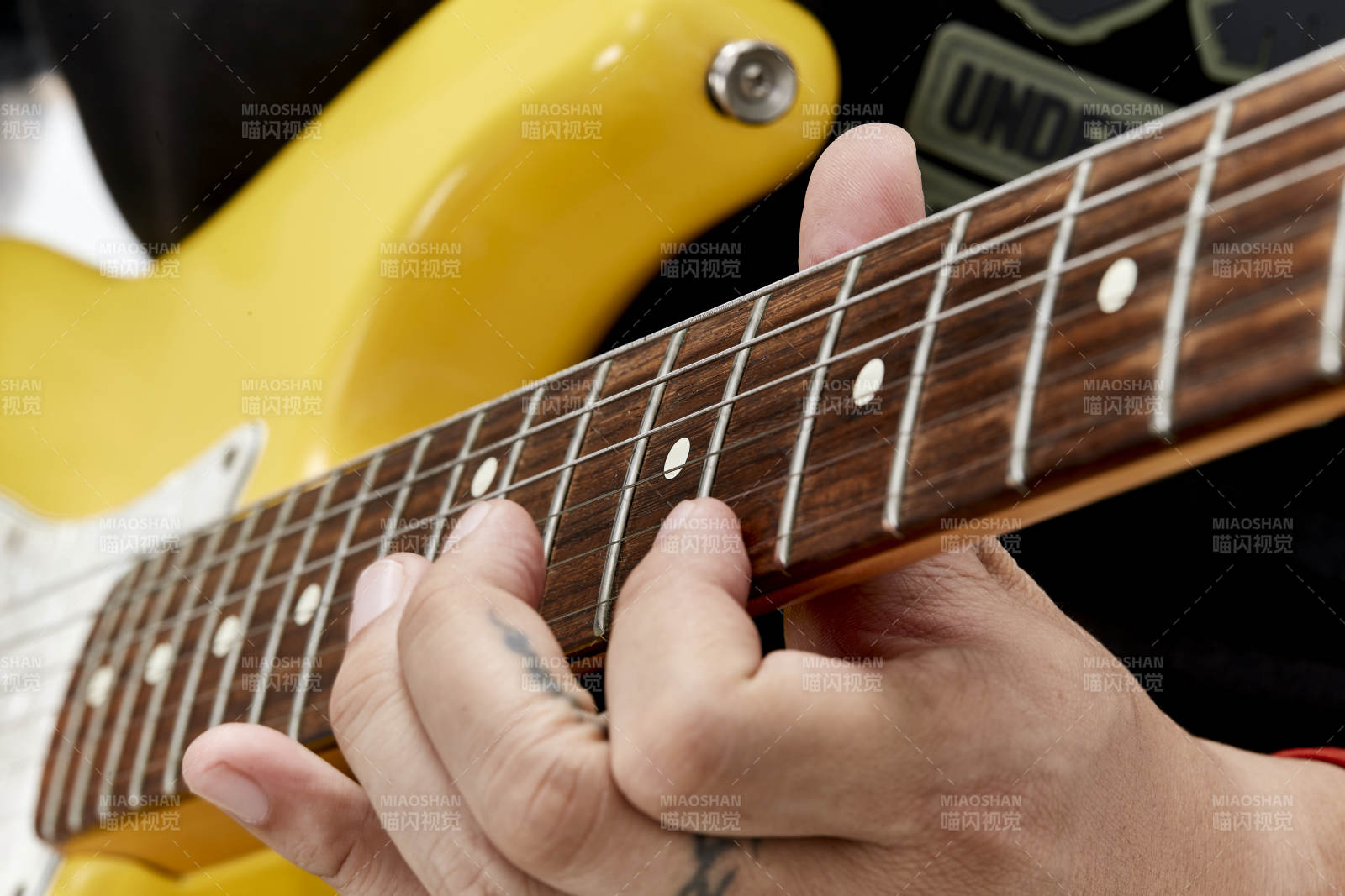 示范演奏搖滾電吉他的亞洲男性樂手人像局部特寫