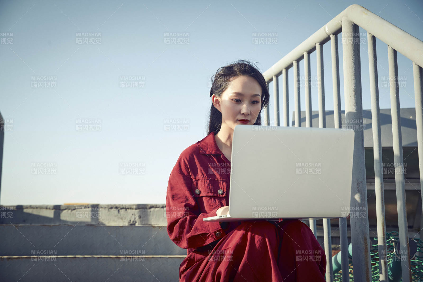 亚洲商务年轻女性在楼顶停机坪使用电脑办公