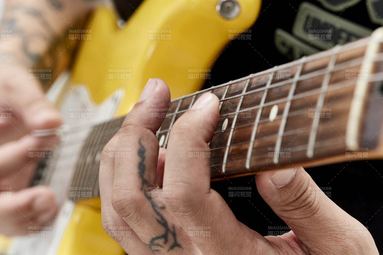 示范演奏摇滚电吉他的亚洲男性乐手人像局部特写