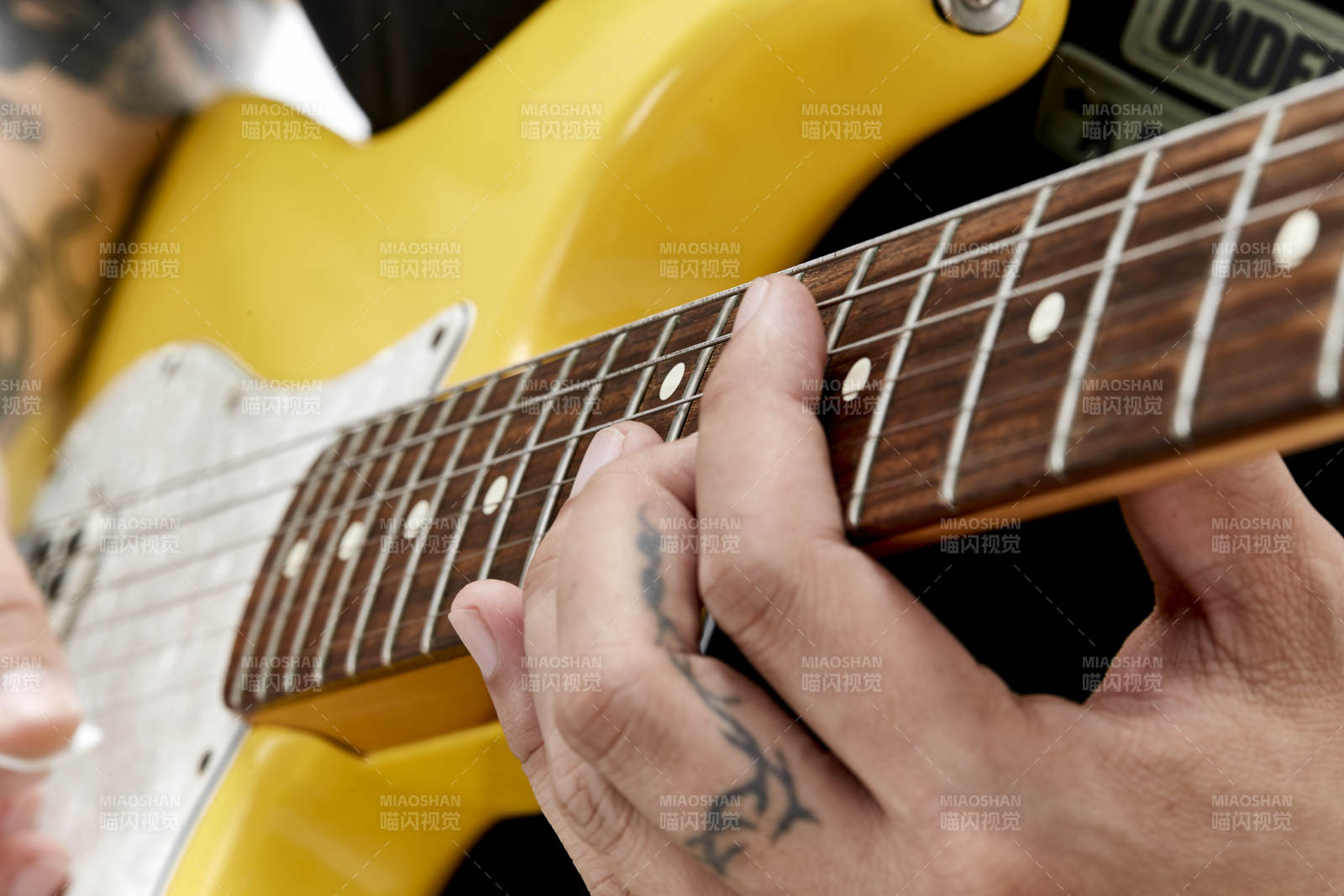 示范演奏搖滾電吉他的亞洲男性樂手人像局部特寫