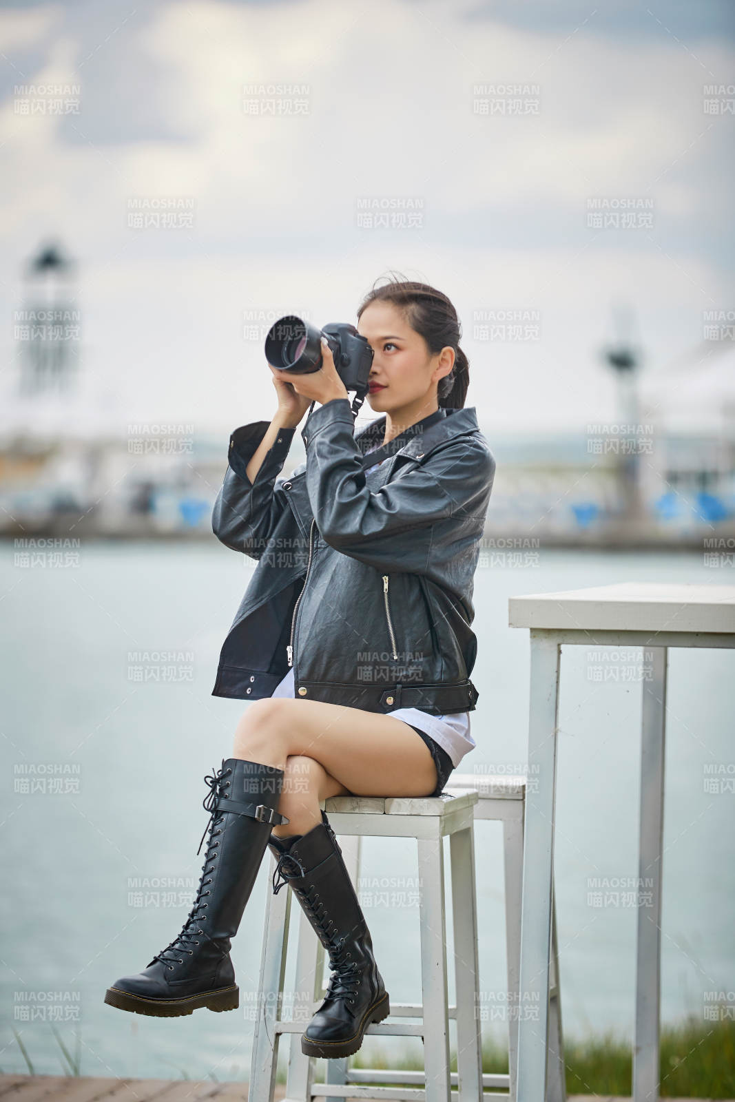 户外湖畔进行拍摄的亚洲青年女性摄影师