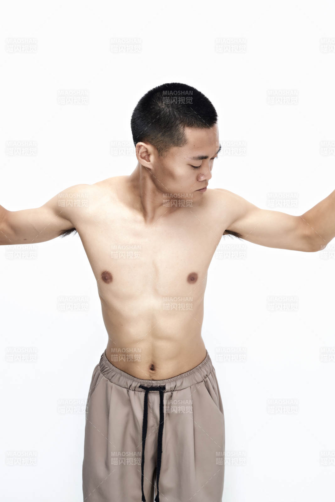 白色背景下展示健身預備拉伸動作的亞洲男性