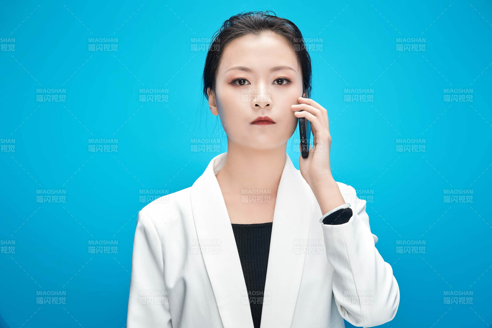 身穿西服拿着手机与文件夹的亚洲商务女士