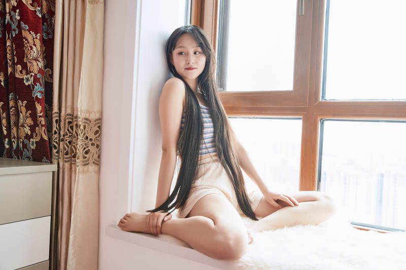 躺在舒适的飘窗上听音乐追剧的亚洲少女