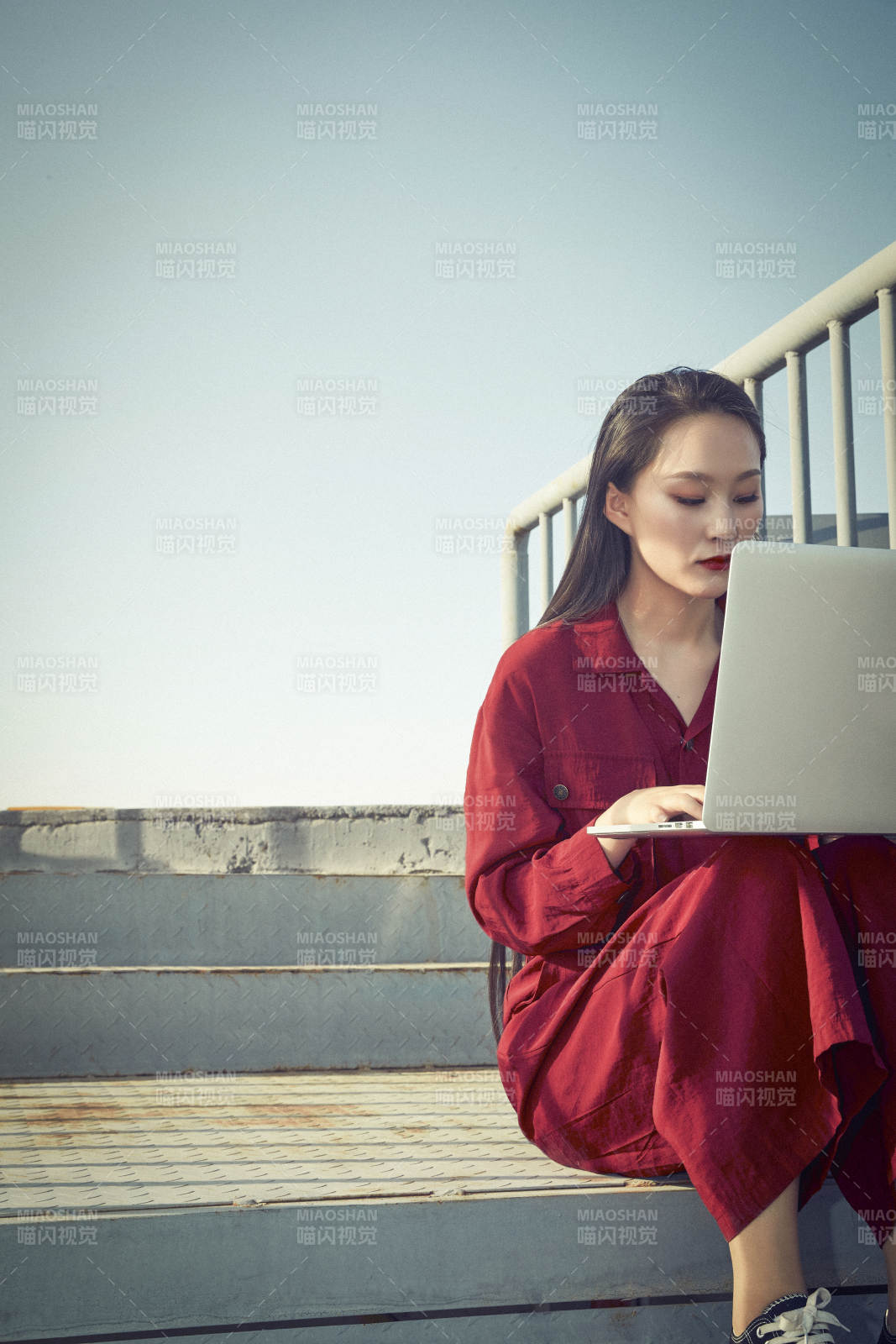 亚洲商务年轻女性在楼顶停机坪使用电脑办公