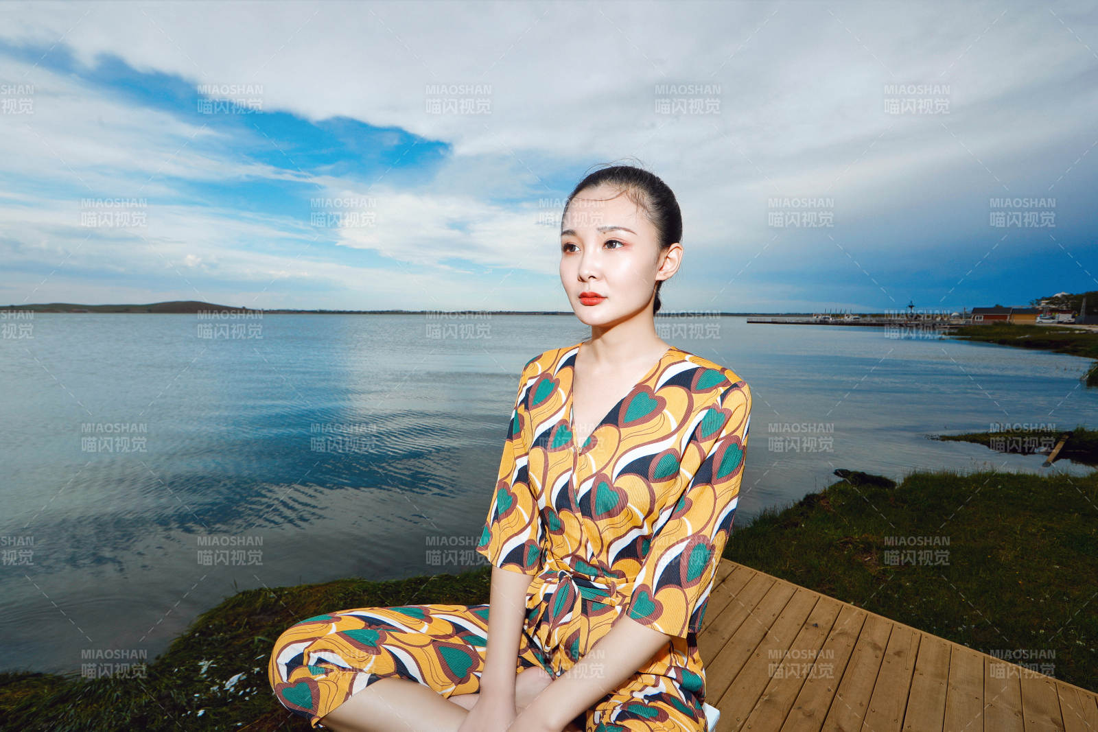 悠闲的坐在美丽湖岸码头的亚洲年轻女性人像