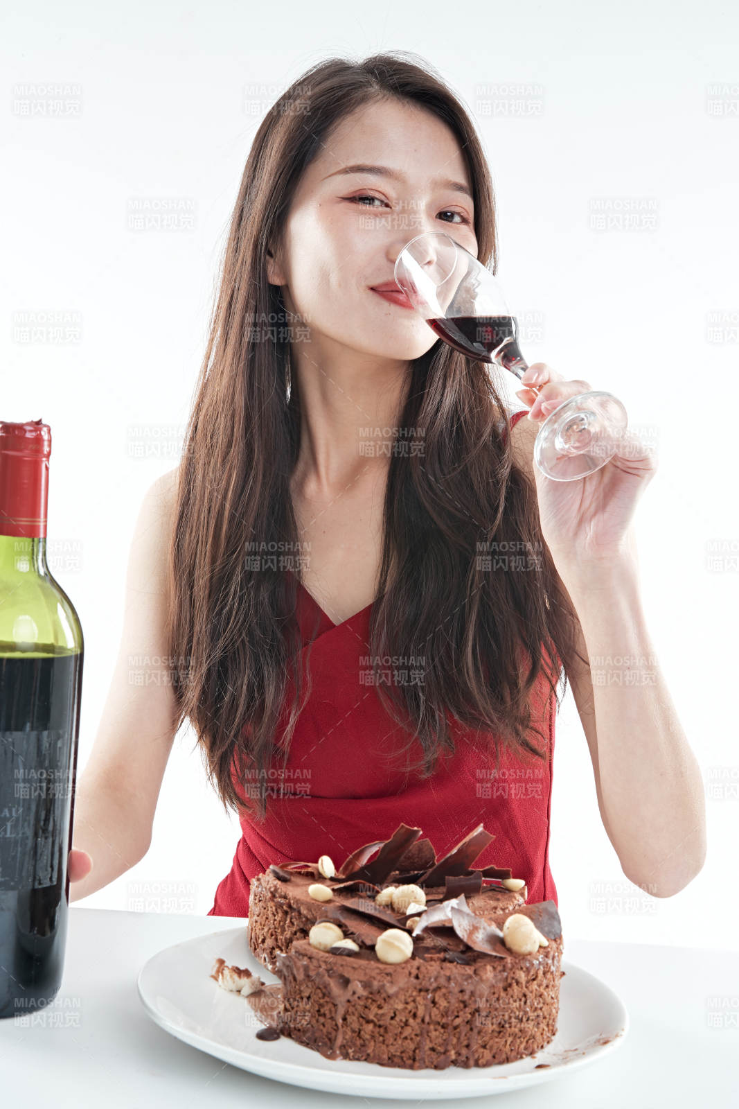 喝红酒品尝蛋糕的年轻女性图片