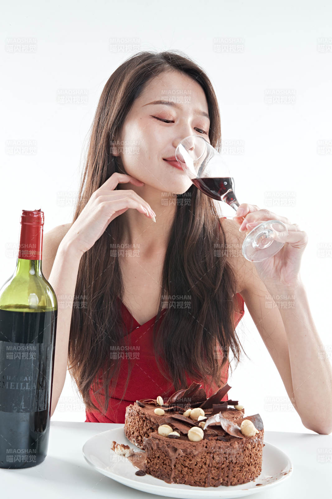 喝红酒品尝蛋糕的年轻女性