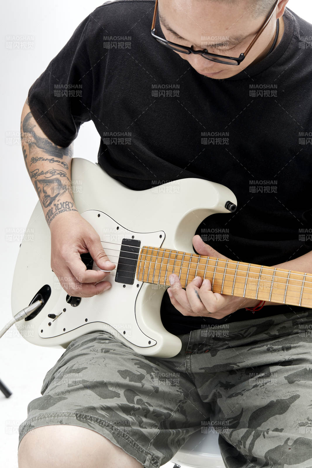示范演奏搖滾電吉他的亞洲男性樂手人像局部特寫